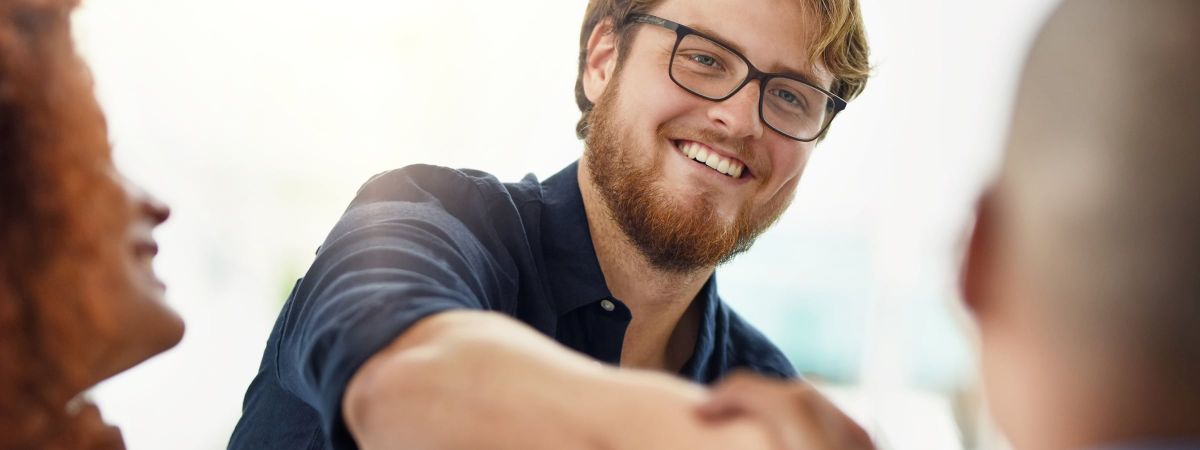 Ein Mann reicht einer anderen Person die Hand.