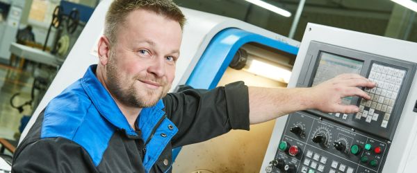 cnc maschinenbediener an einer Anlage im Industriebetrieb