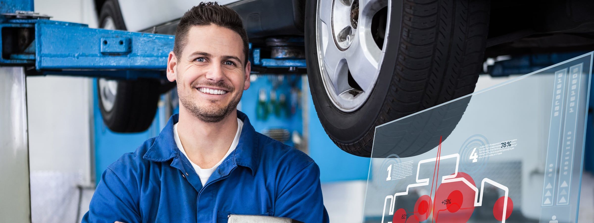 Automechaniker steht vor einer Hebebühne auf der eine Auto ist.