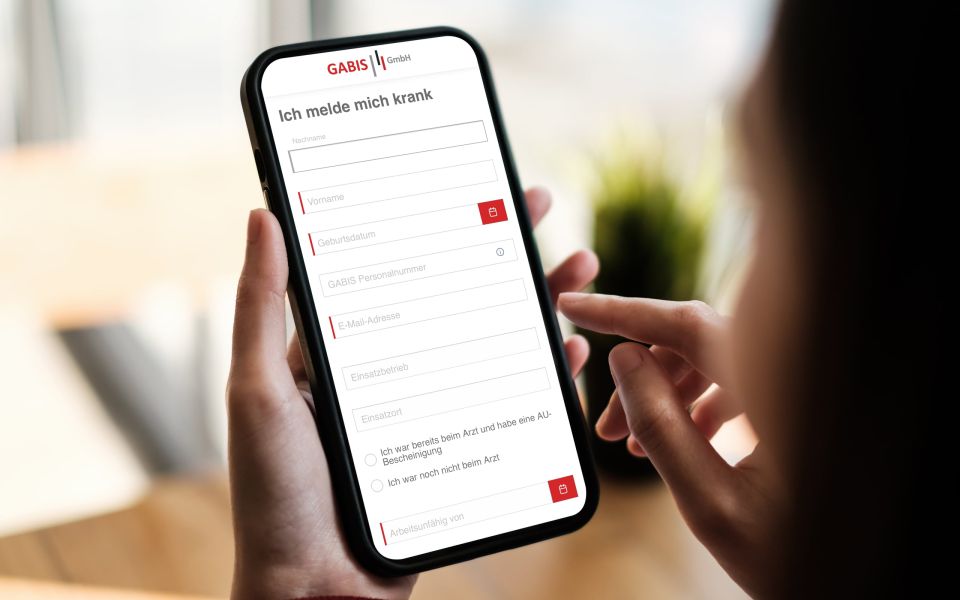 Eine Person hält ein Smarthone auf dem das Krankmelde-Formular der Gabis geöffnet ist.