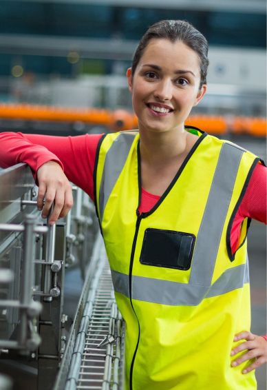 Lagermitarbeiterin steht vor einem Fließband.